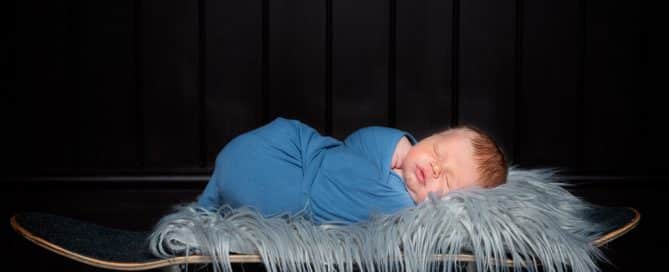 a newborn asleep on a skateboard