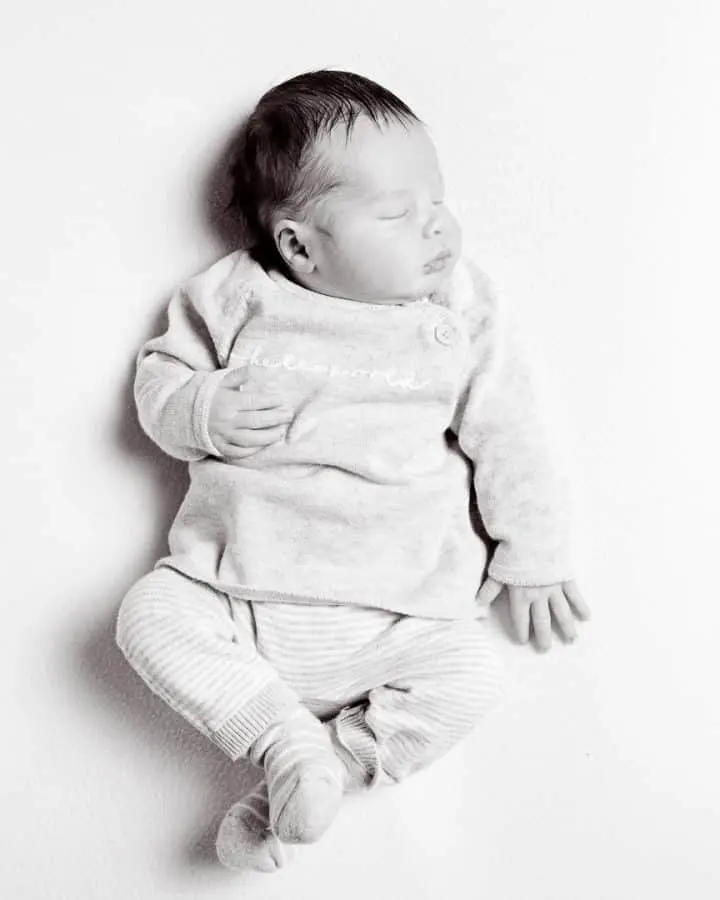 a black and white image of a sleeping newborn viewed from the top