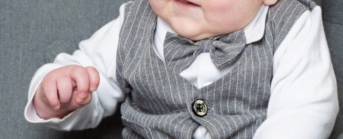 a baby in a grey pinstripe suit at a photo shoot