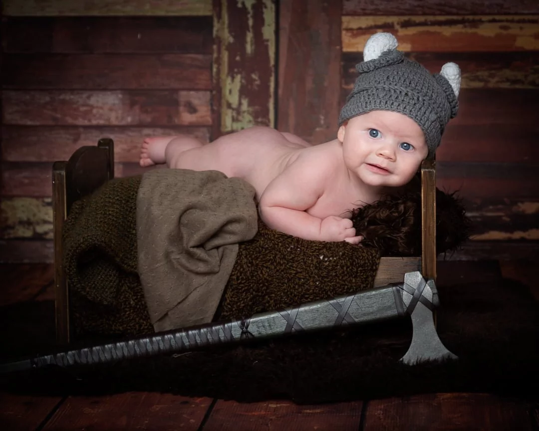 Baby Photography East Grinstead West Sussex a baby on a bed dressed as a Viking at a themed photo shoot