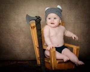 a little boy in a wooden throne at a Viking themed photo shoot