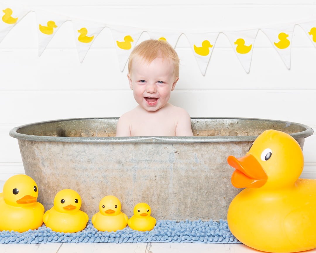 a duck themed tub splash photo shoot with a white backdrop