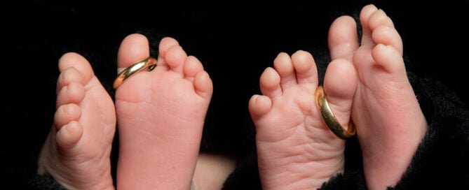 two sets of newborn feet at a twin photo shoot