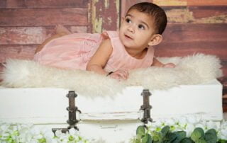 a little girl in a peach outfit on my vintage suitcase prop