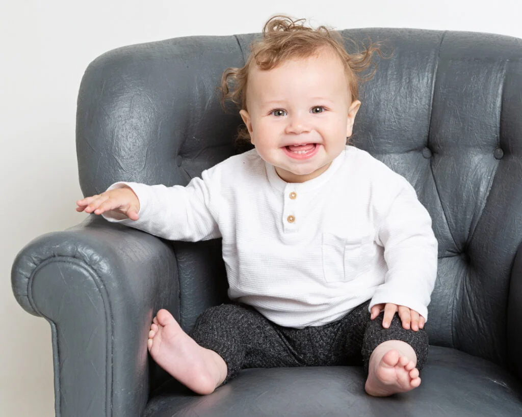 a little boy with fluffy hair poses for a photo