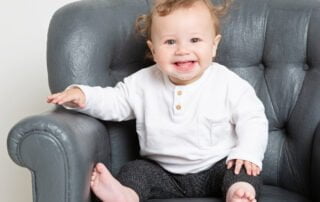 a little boy with fluffy hair poses for a photo