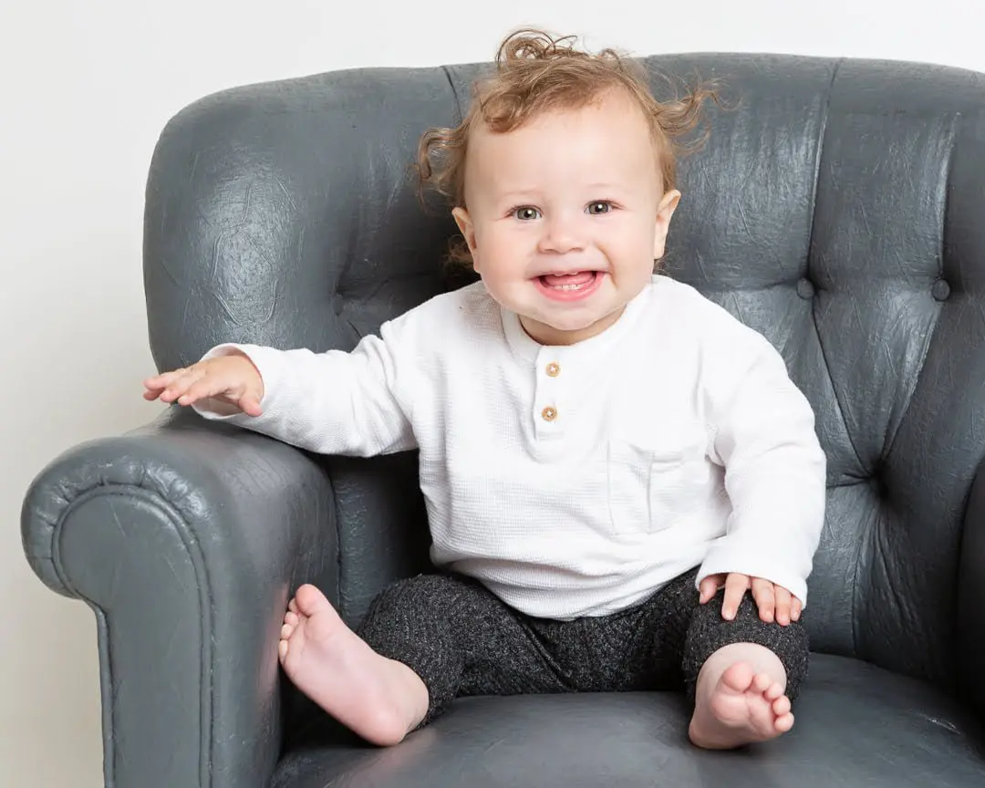a little boy with fluffy hair poses for a photo