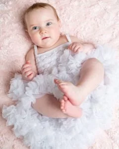 a little girl in a fluffy white pettidress