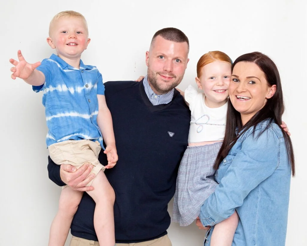Family Portrait Photo Shoot East Grinstead West Sussex a family with two young children stand for a family portrait in my West Sussex studio