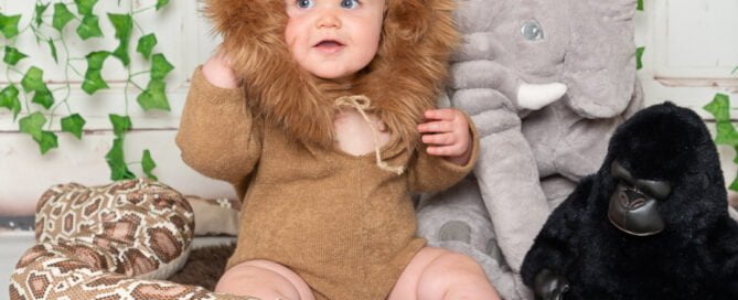 a little boy in a lion outfit with jungle themed props and toys