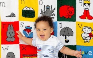 a little boy and his personalised alphabet themed blanket