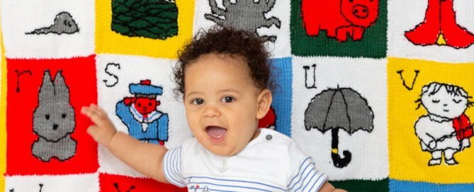 a little boy and his personalised alphabet themed blanket