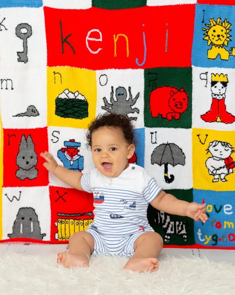 a little boy and his personalised alphabet themed blanket