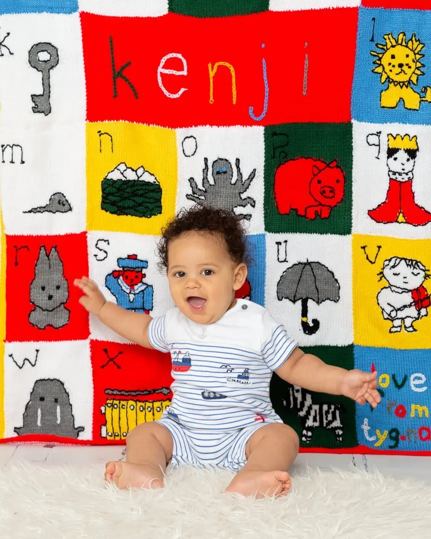 a little boy and his personalised alphabet themed blanket