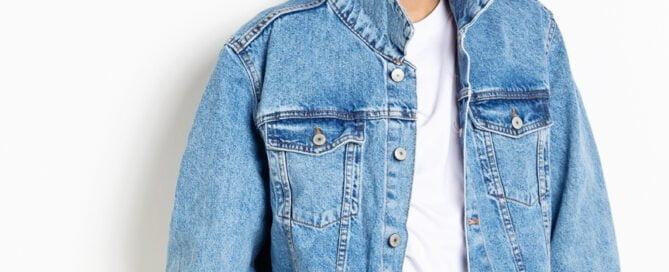 A young man poses in a denim jacket for a professional photo
