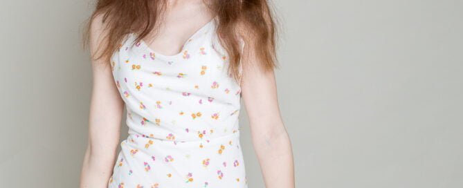 a girl poses for a portrait in a floral dress
