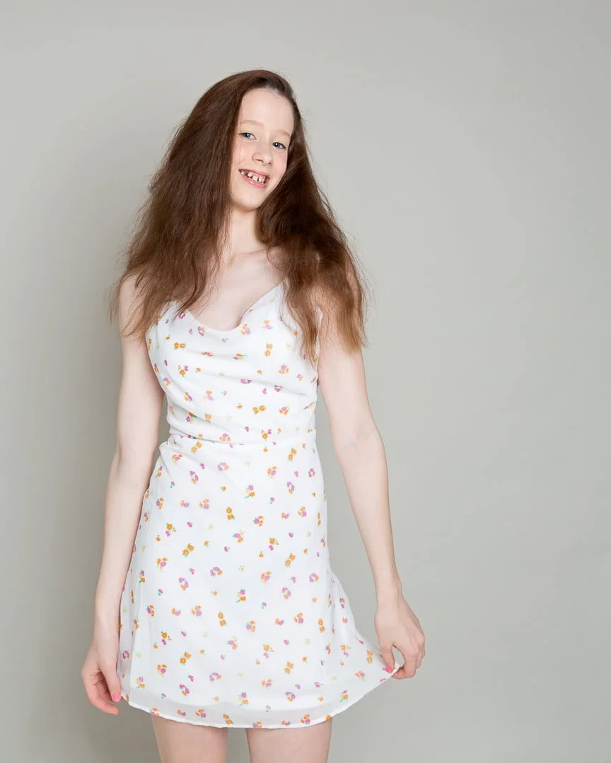 a girl poses for a portrait in a floral dress