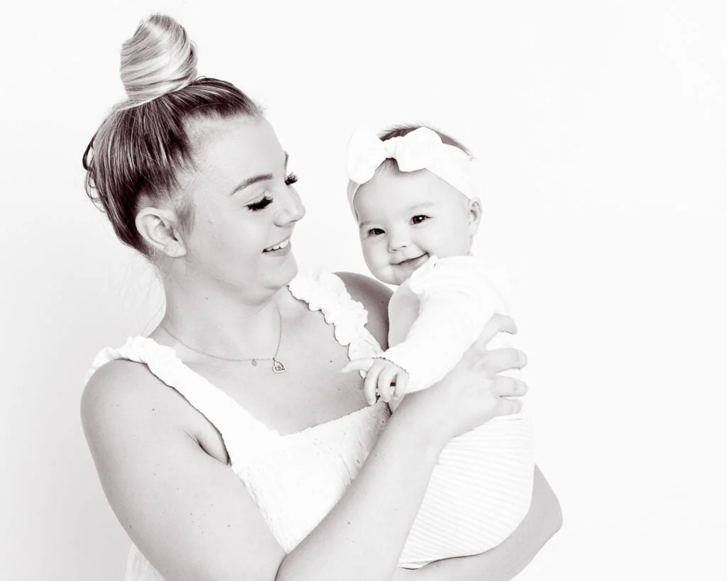 a black and white image of a mum and daughter both laughing
