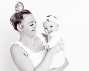 a black and white image of a mum and daughter both laughing
