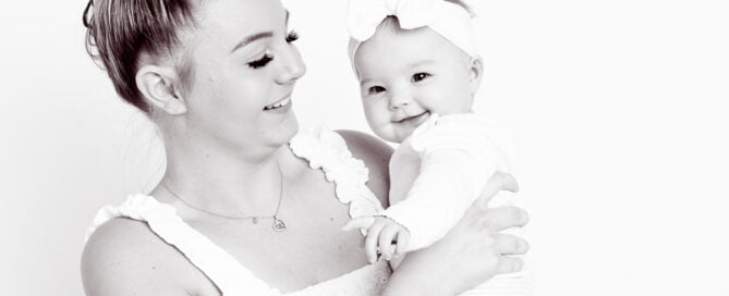 a black and white image of a mum and daughter both laughing