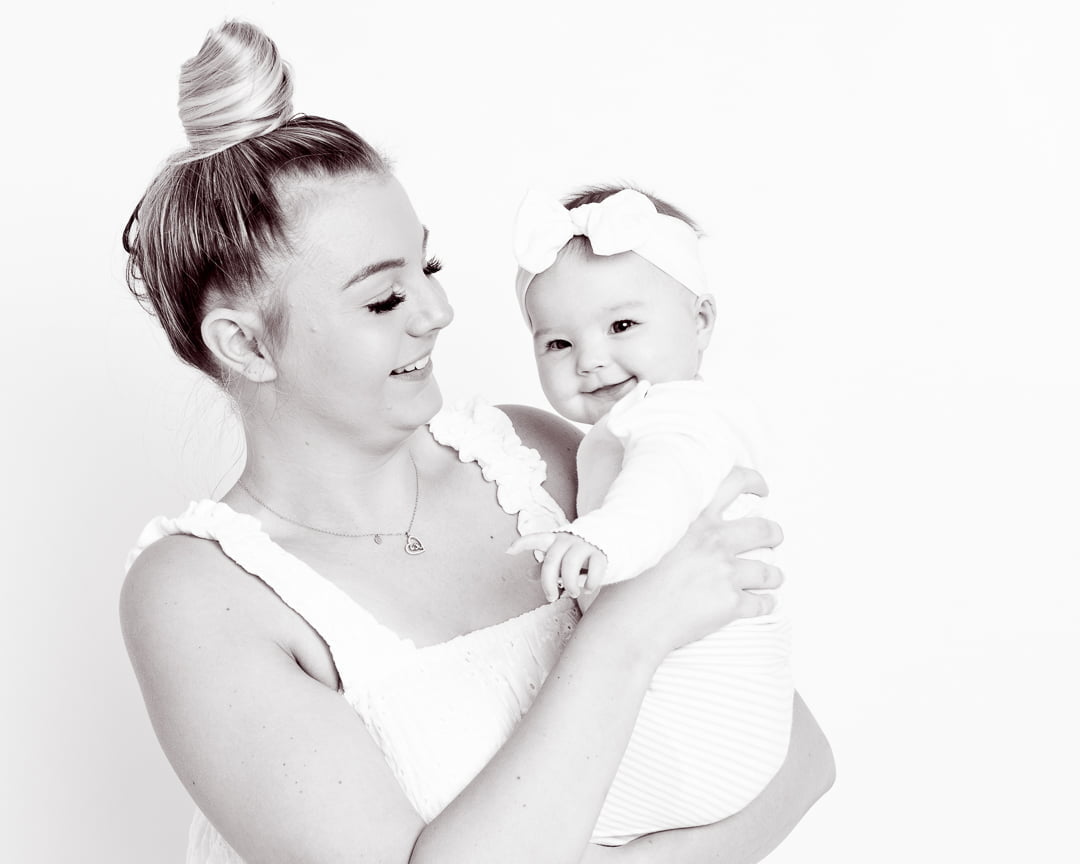 a black and white image of a mum and daughter both laughing