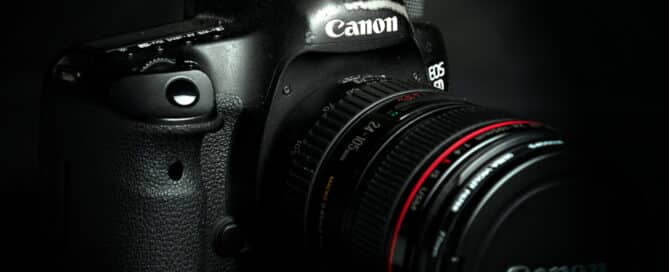 A black Canon Camera photographed against a black background