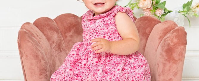 a little girl with a pink dress and curly hair