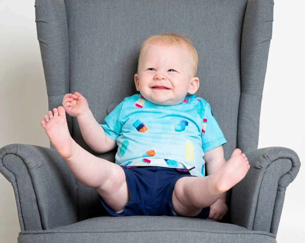 a little boy is so excited that his legs are flying up in the air