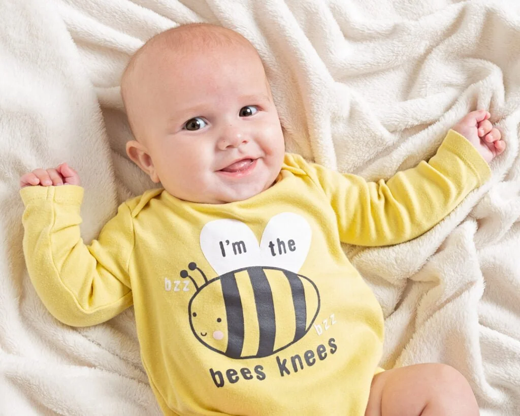 Baby Photography East Grinstead West Sussex a baby in a bee themed vest in a photo shoot