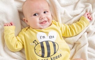 a baby in a bee themed vest in a photo shoot