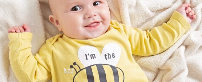 a baby in a bee themed vest in a photo shoot