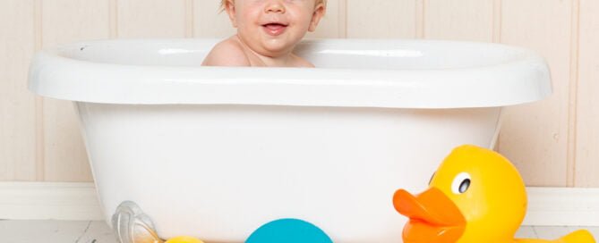 a duck themed tub splash photo shoot with a cream backdrop
