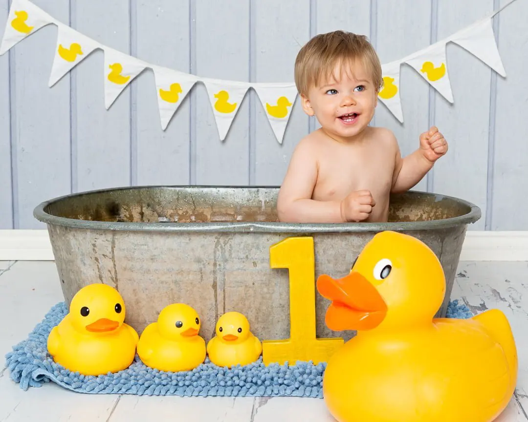 a duck themed tub splash photo shoot with a blue backdrop