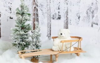 a wooden sledge in a christmas snowy themed photo shoot set
