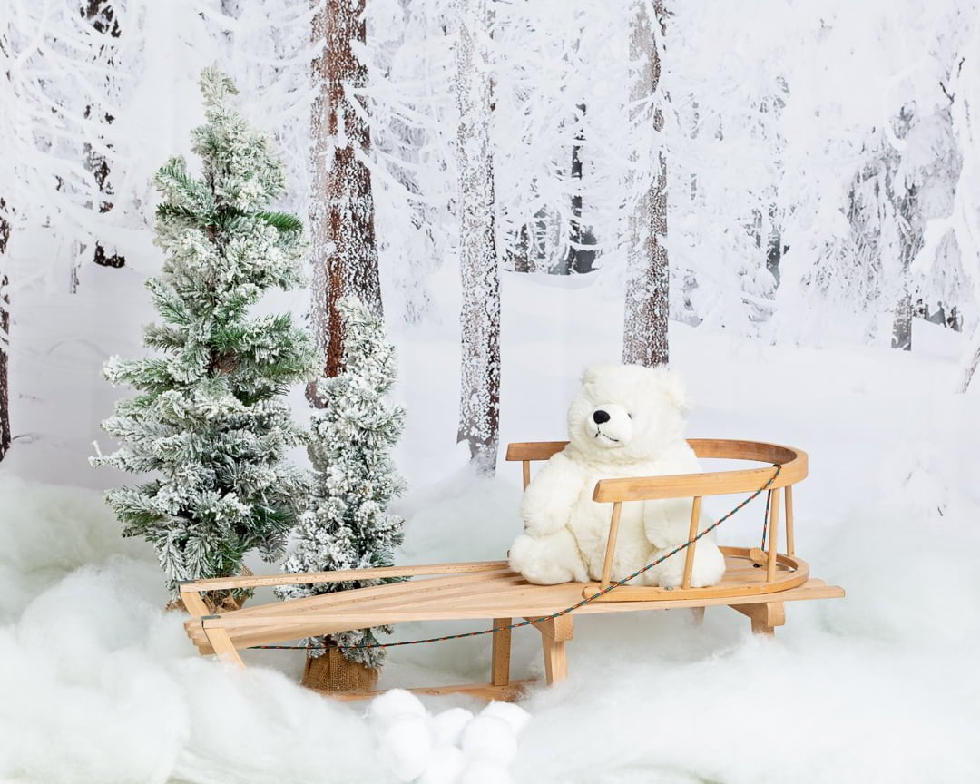 a wooden sledge in a christmas snowy themed photo shoot set