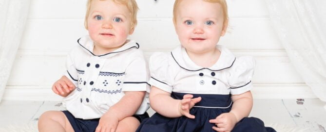 Twins pose in matching navy and white outfits