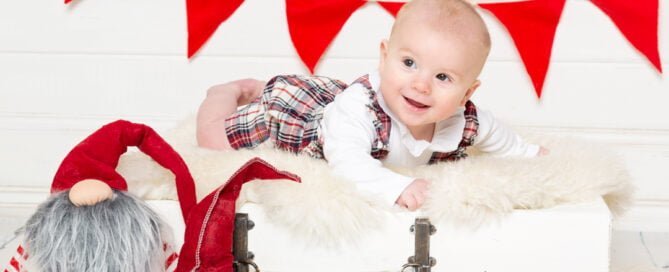 a baby with red and white festive props