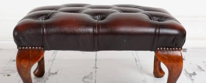Brown leather footstool studio prop