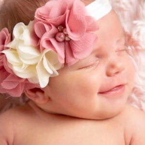 a newborn with a big smile on her face