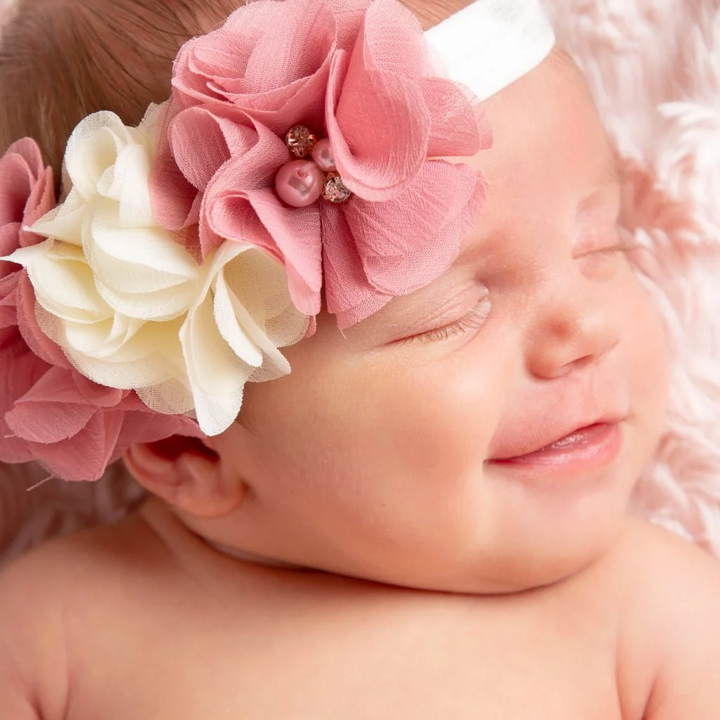 a newborn with a big smile on her face