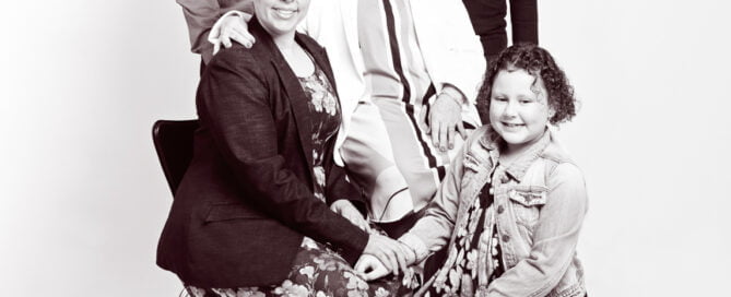 Three generations of family posing for a studio family portrait