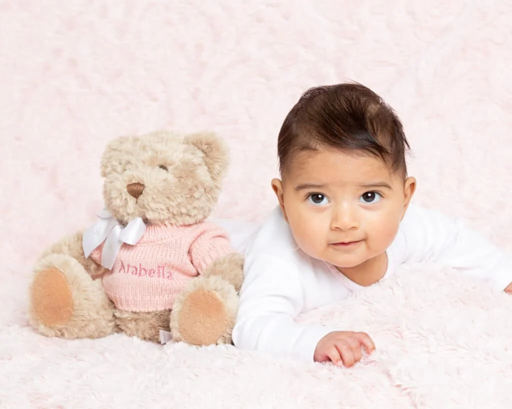 a baby and a pink personalised teddy bear