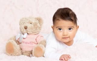 a baby and a pink personalised teddy bear