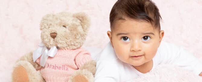 a baby and a pink personalised teddy bear