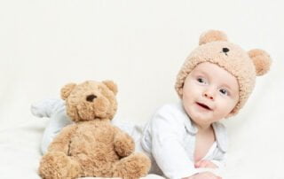 a little boy in a teddy bear hat with a teddy bear