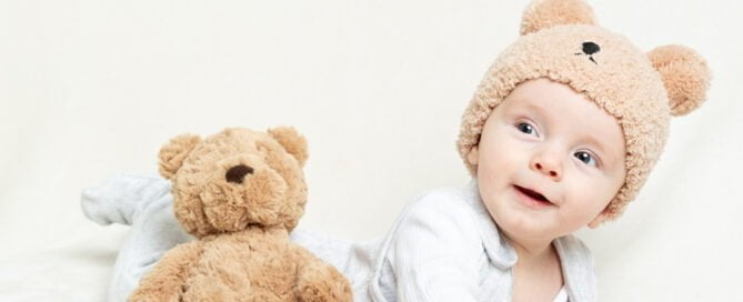 a little boy in a teddy bear hat with a teddy bear