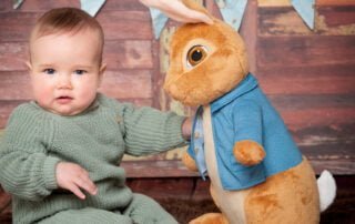 a baby and a large Peter Rabbit Toy