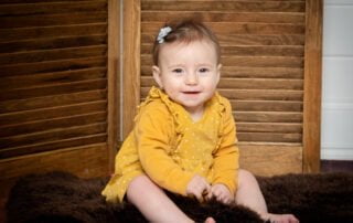 a little girl in a mustard colour outfit
