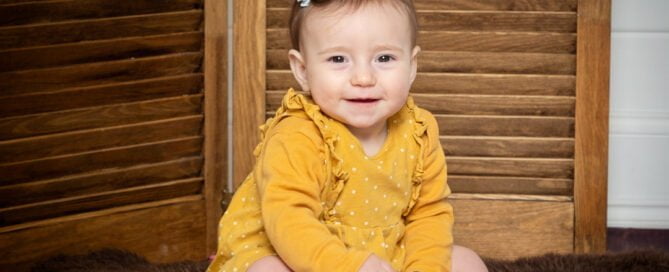 a little girl in a mustard colour outfit