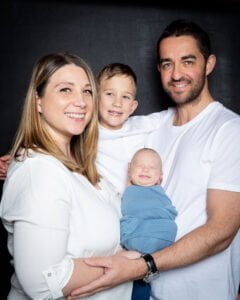 a family of for in. Matching white T-shirt s with a baby in blue